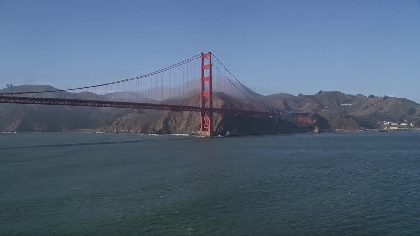 Panorama of the golden gate bridge over the vast sea that connects mountains during a blue sky day