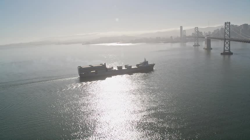 A cargo ship is sailing under the golden gate bridge in san francisco