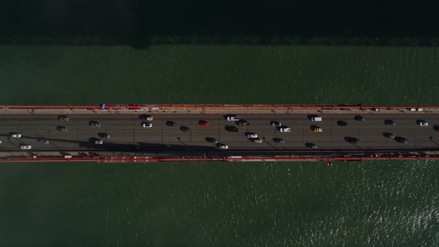 Aerial view of traffic on a suspension bridge over the ocean