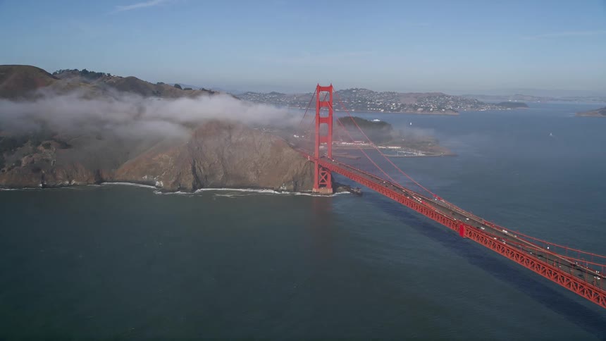 Aerial panorama of the golden gate bridge over a vast blue sea connecting mountains and cities during the day