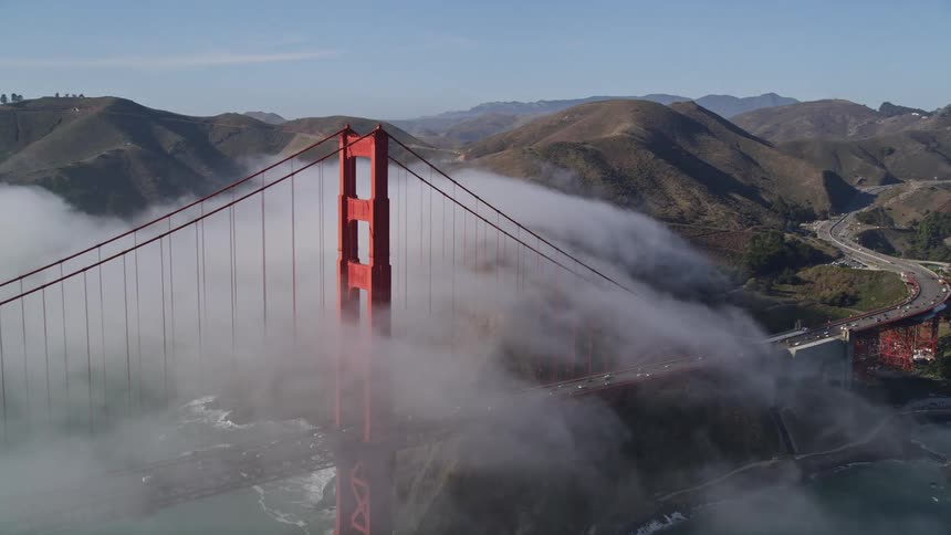 Aerial panorama of the golden gate bridge on a foggy day with vehicle traffic