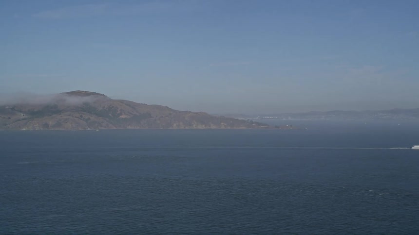 Aerial panorama of a peninsula with mountains and coastline around on a blue sky day