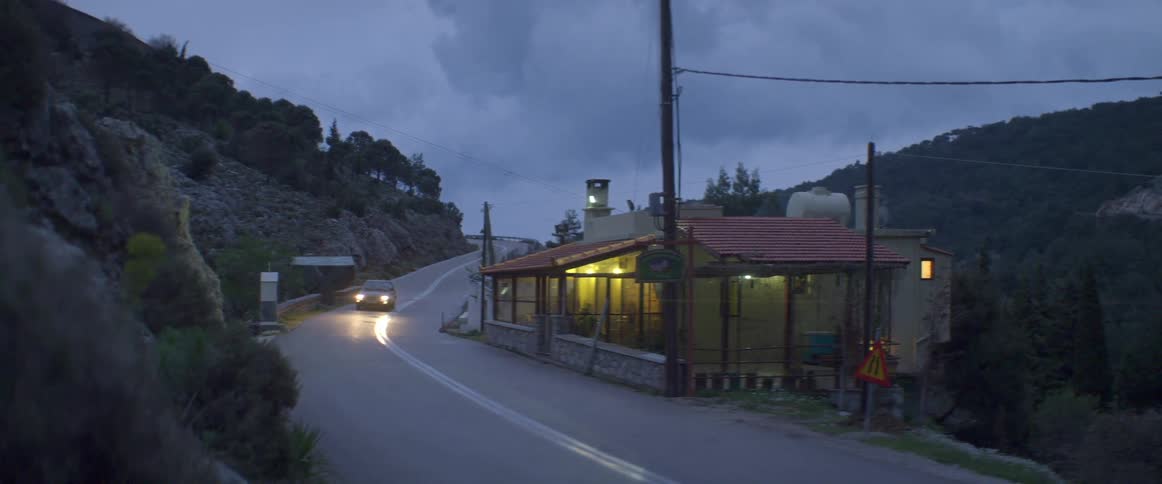 A car drives on a rural road at night