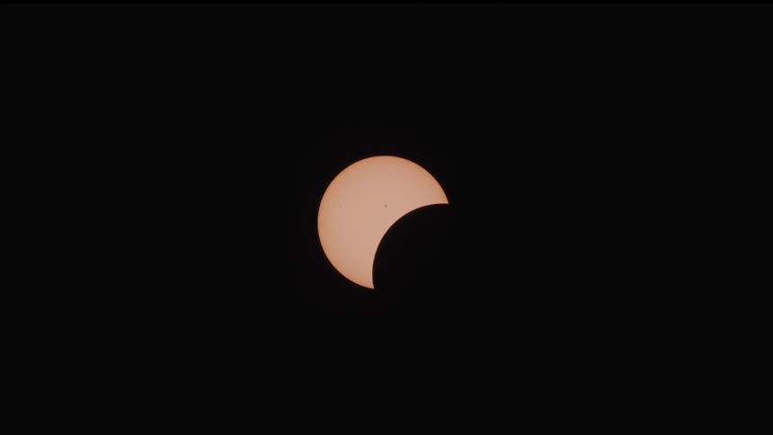 The eclipse slowly moves in the black sky