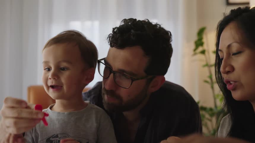 Parents play with their child at home
