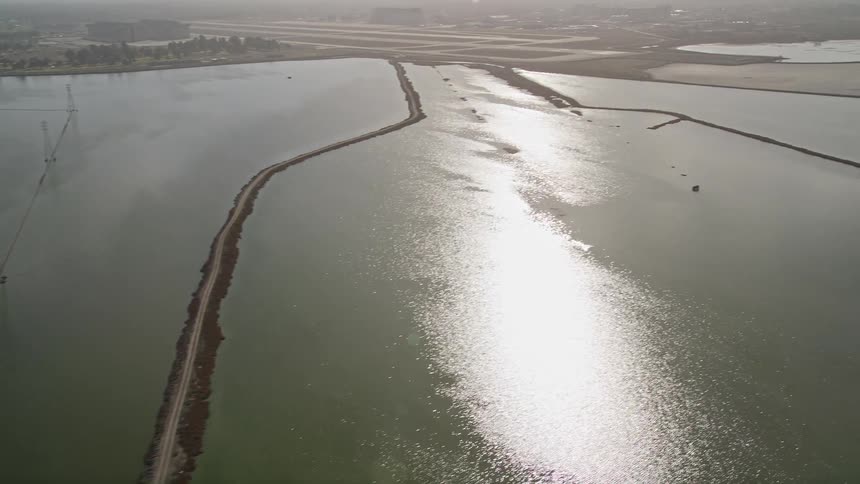 Utility lines run across a body of water near an airport