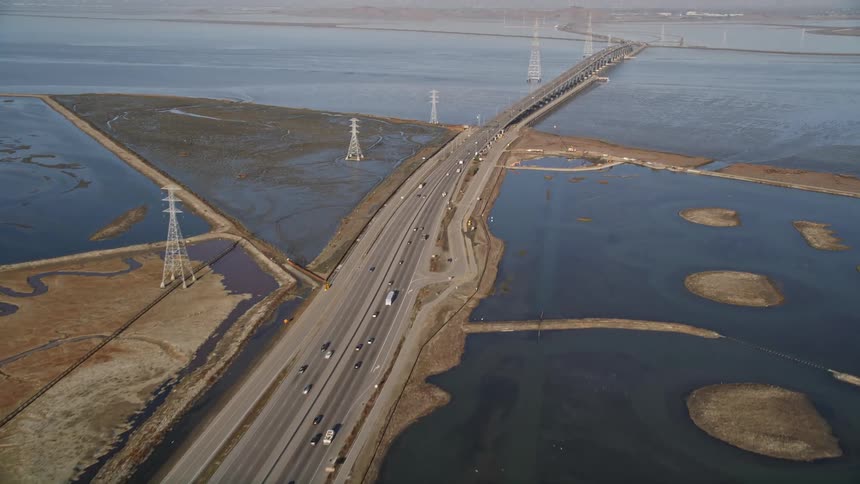 Aerial panorama of a long highway crossing the sea with vehicle traffic