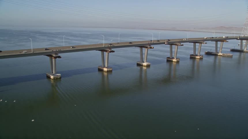 Aerial panorama of a bridge over the sea with vehicle traffic during the day