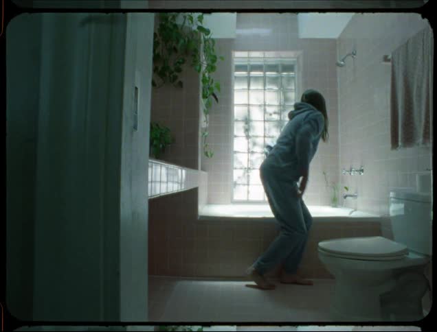 Man finishes filling the bathtub then stands to undress