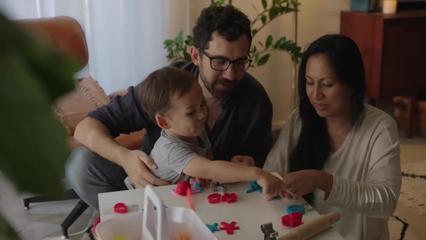A family plays with a toys on a small table