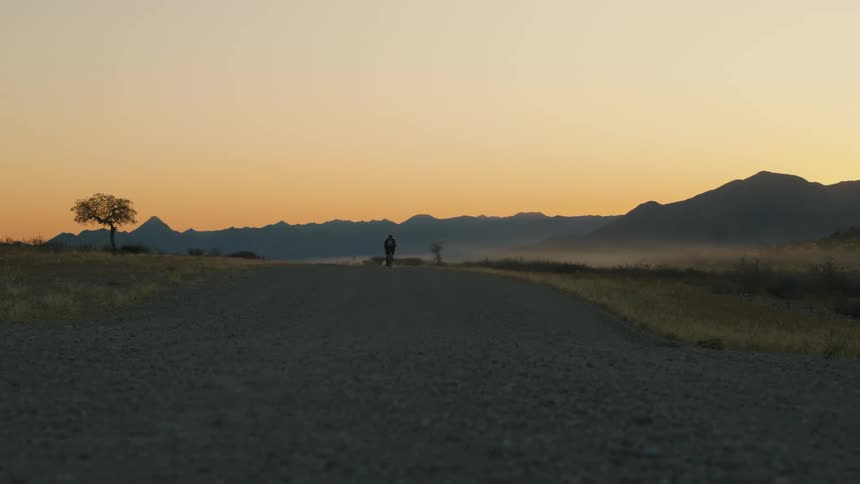 A person rides a bike down a remote road
