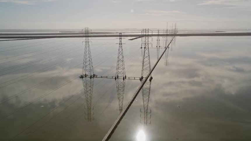 Aerial panorama of a water reservoir with power transmission towers