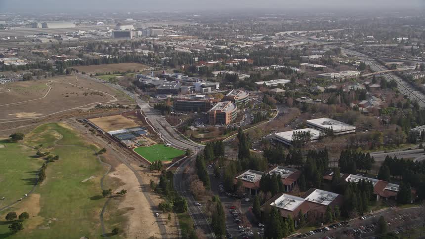 Aerial panorama of an urban city with commercial buildings and wooded areas