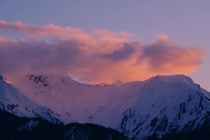 Clouds sit on the peak of the mountain
