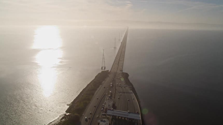 Aerial view of a lengthy bridge extending across a wide expanse of water