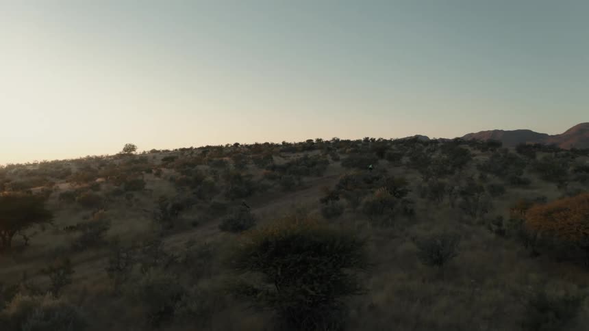 Cyclist riding his bike on a dirt street on a natural hill in the morning