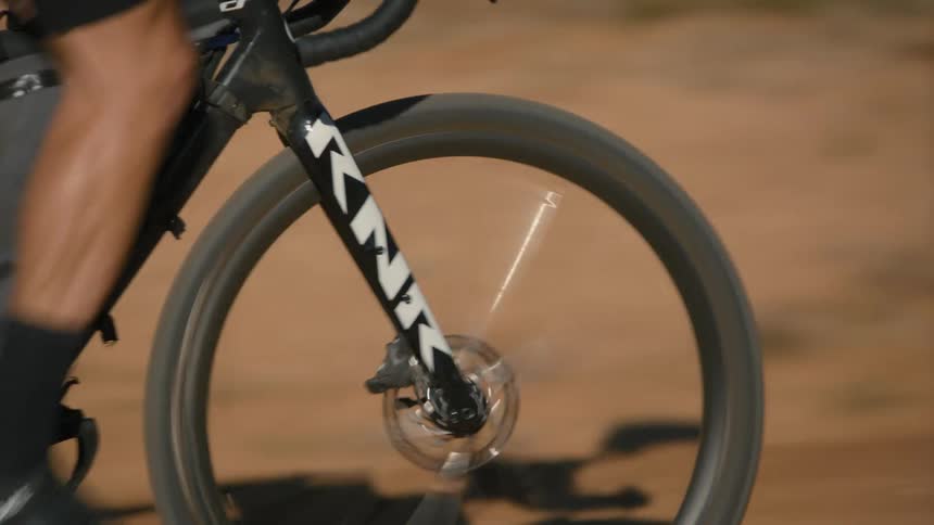 Legs of a person pedaling a bicycle in an outdoor environment