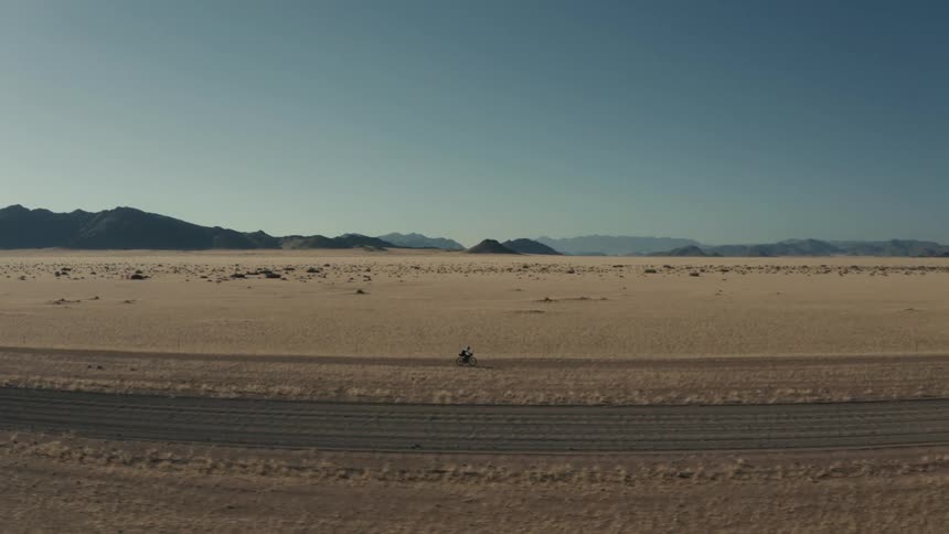 A bicyclist rides on a path in a nature