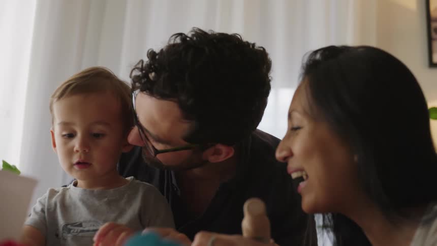 Two parents play with their toddler child