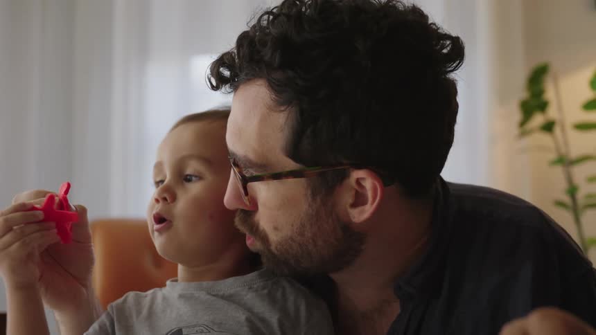 Father and son play with figures made out of colored clay