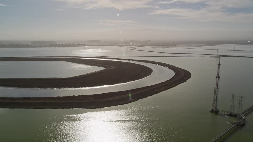 Aerial panorama of a river reservoir with power transmission towers during the day