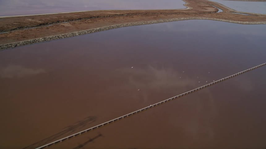 Aerial scenery of a water reservoir with power transmission towers