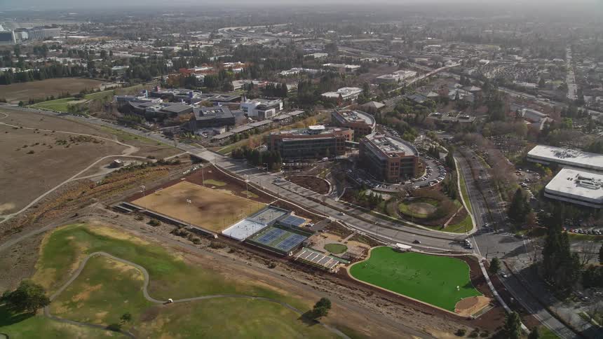 An aerial view of a city with a residential area near empty fields