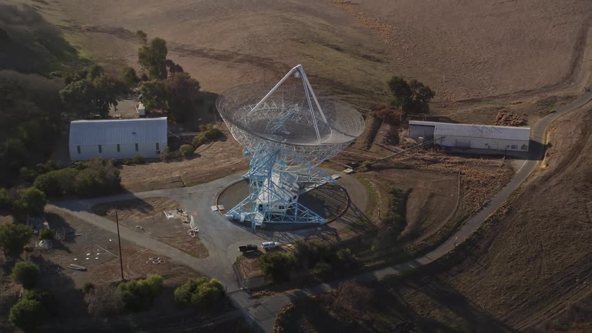 A large satellite dish in the middle of a field