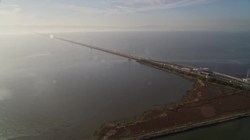 Vehicles travel on the long strips of road on the water