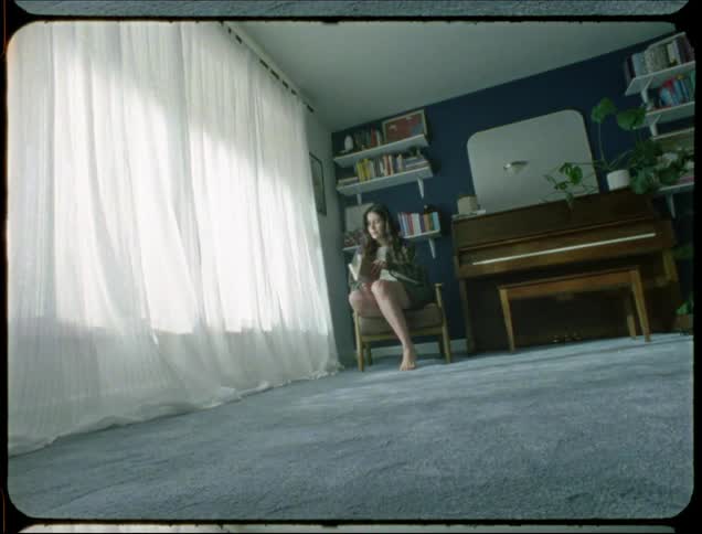 Young woman sitting in an armchair and reading a book