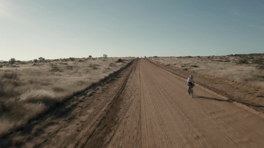 A person is riding their bike on the dirt road
