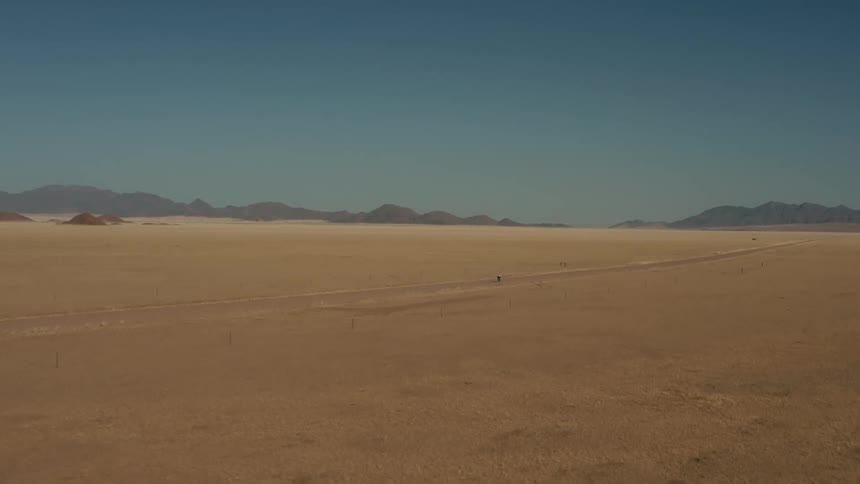 A bicyclist rides across a vast grassland