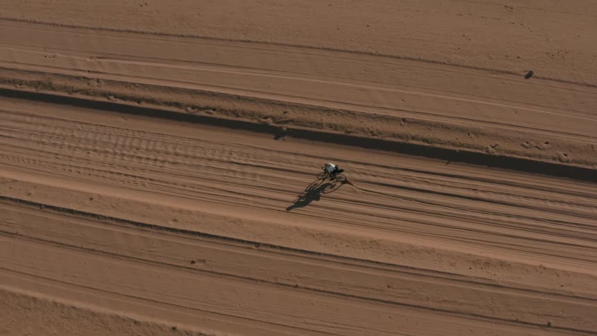 An aerial footage of a person riding a bike in the desert