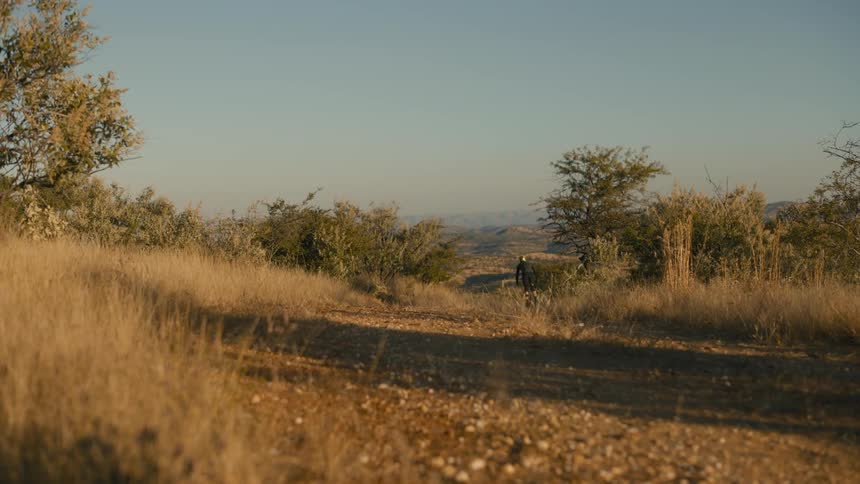 Mountain bike person pedaling on a dirt road in hills in nature