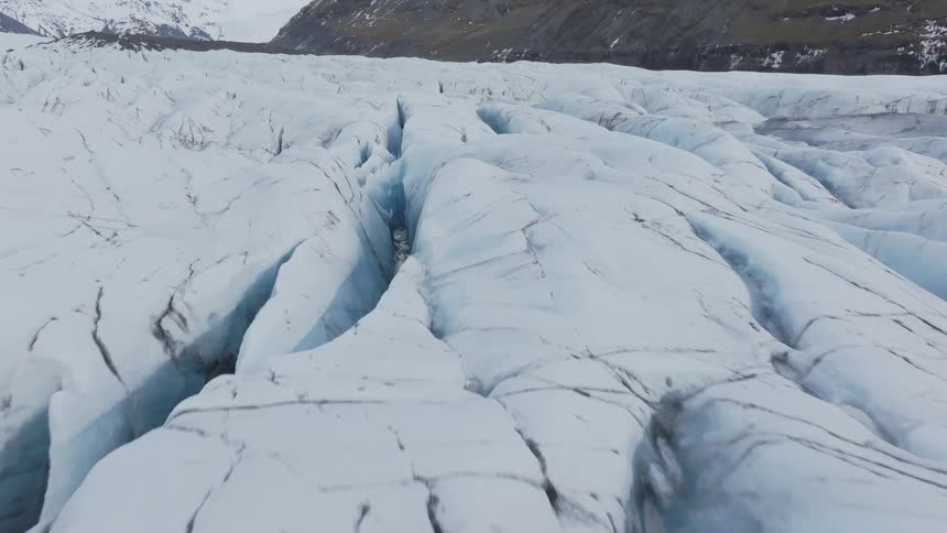 Mountain region is the one with the ground covered in snow and several fissures in it