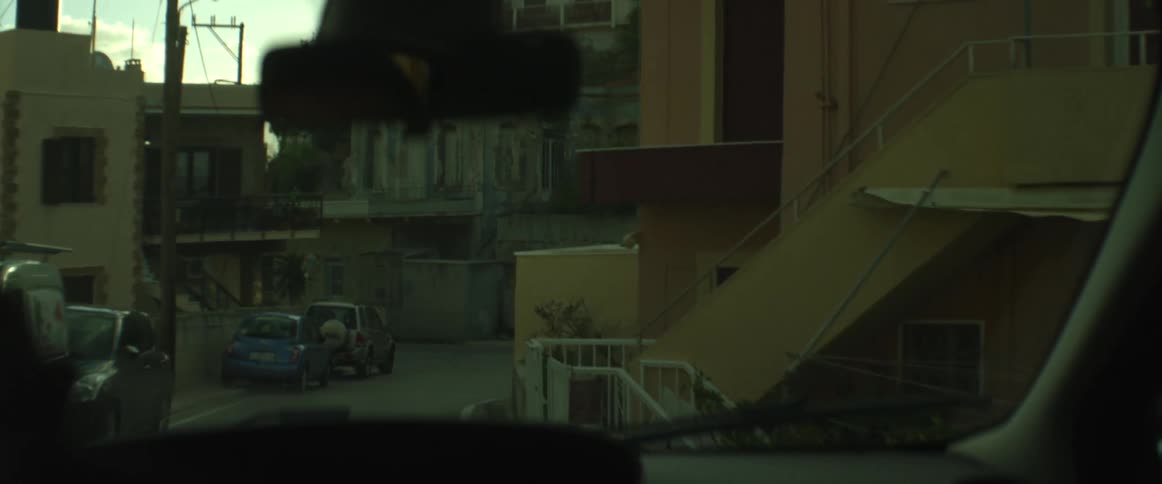 A village as seen through the windshield of a car