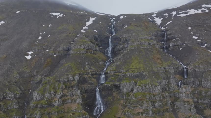 Melting snow leads to waterfalls cascading down a mountain
