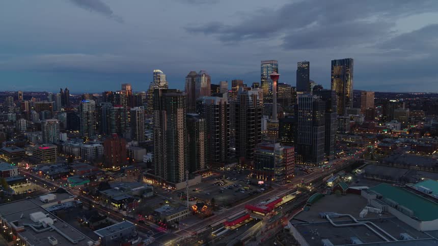 Closing aerial dolly out of urban metropolis at dusk