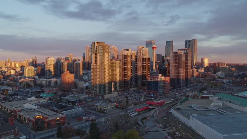 Aerial crane view of sun shining onto a downtown metropolis at dawn