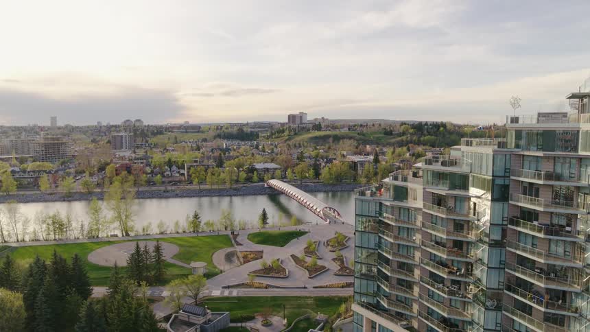 Urban landscaping and modern bridge across a river on a summer evening