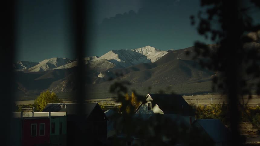 View from the window of a residential neighborhood with snowy mountains on the horizon