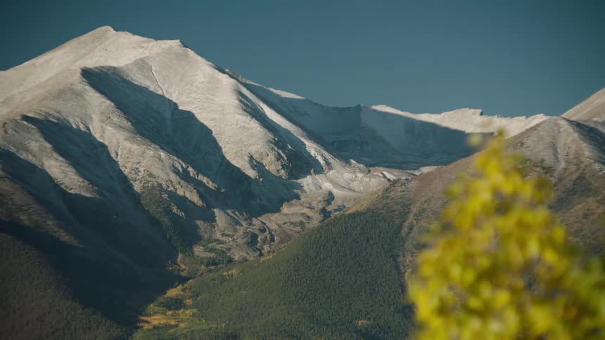 Landscape of a masculine forest and mountain ranges on a cloudless blue sky day