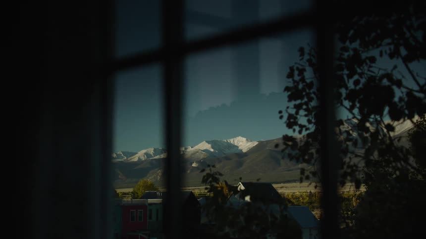 View from the window of a residential neighborhood with hills and mountains in the background on a clear day