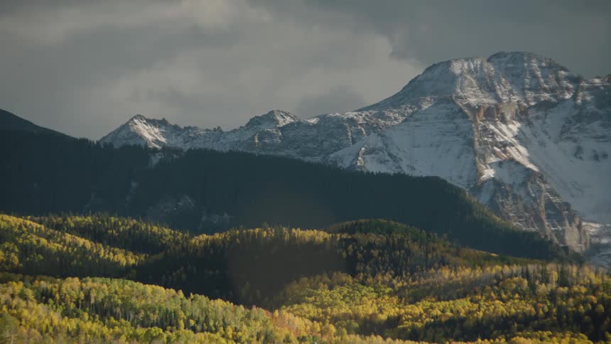 A panoramic view of a mountain range with peaks partially covered in snow