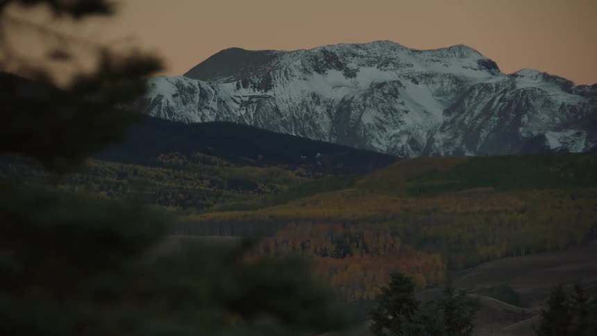 Natural scenery of hills and mountains with snow on a red sky morning