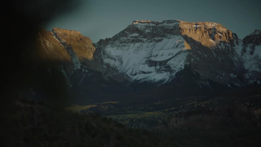 Hills landscape with forests and surrounding mountain with snow