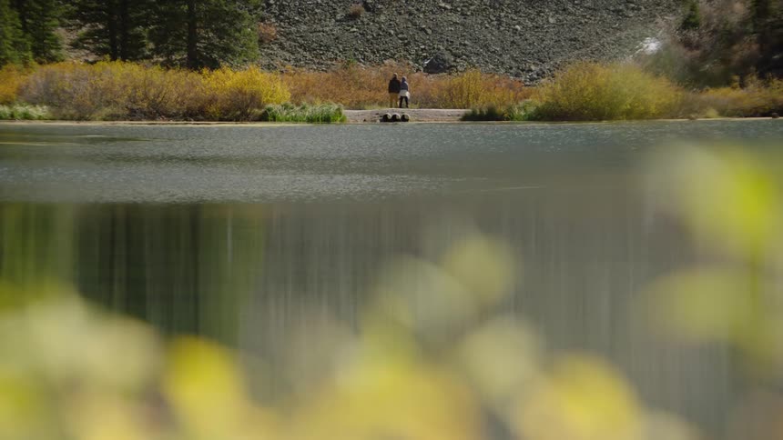 A couple by a lakeside with autumn foliage