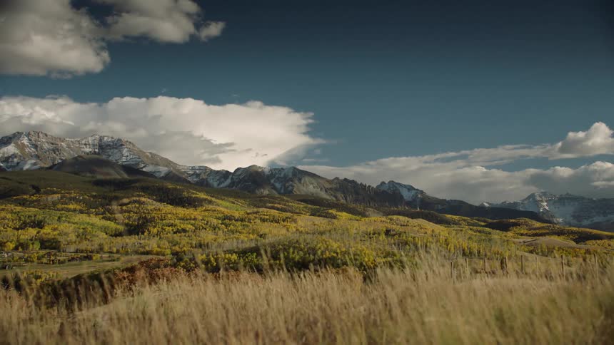 A panoramic view of a mountain range with peaks partially covered in snow
