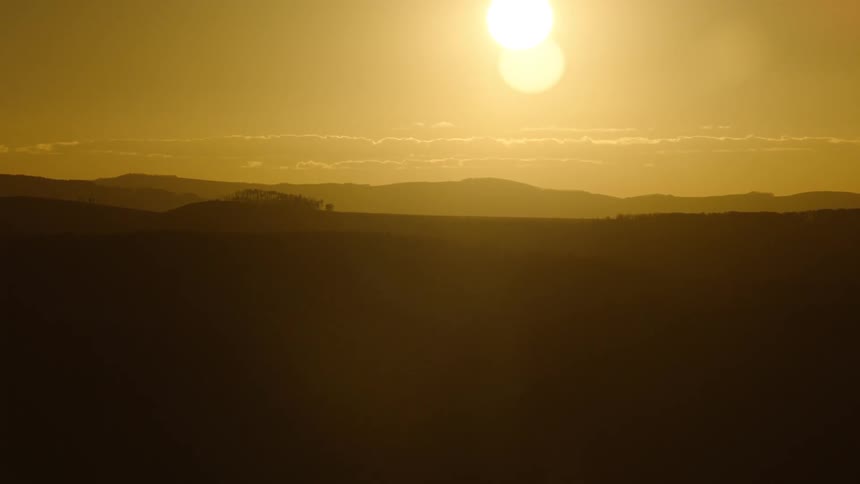 Sunrise over a landscape mountains visible in the distance