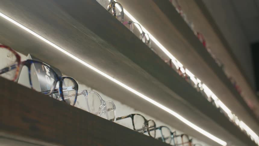The shelves in the sore are lined with glasses